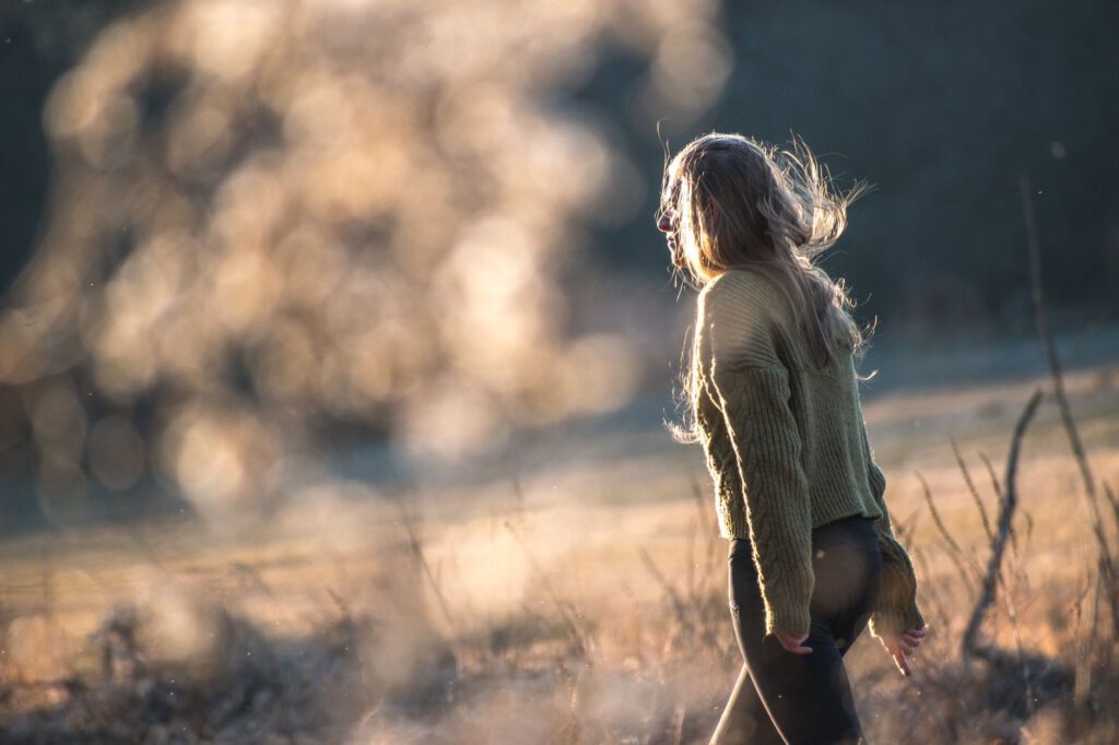 Vrouw wandelt door de natuur in zacht licht